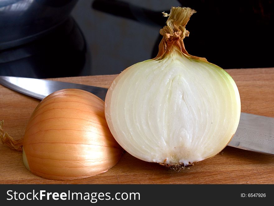 Half of bulb on a chopping board with a knife