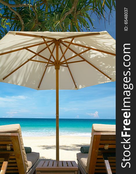 View of two chairs and white umbrella on the beach. View of two chairs and white umbrella on the beach.