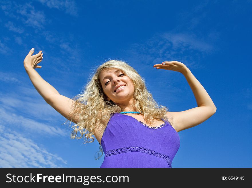 Happy beautiful girl is smiling against blue sky