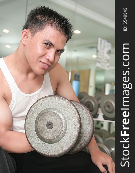 Man lifting barbell in fitness center. Man lifting barbell in fitness center