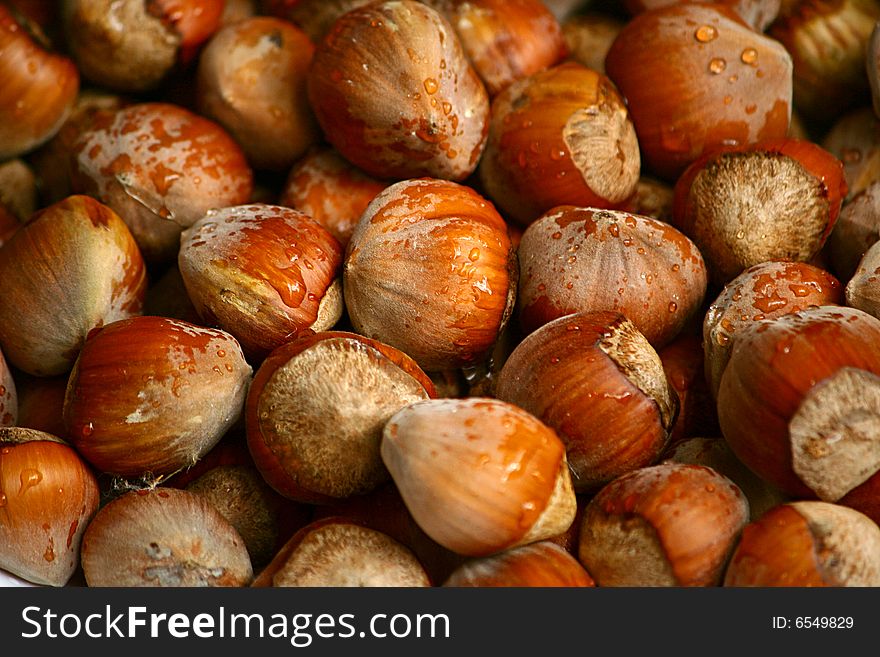 An image of many hazelnuts with water drops