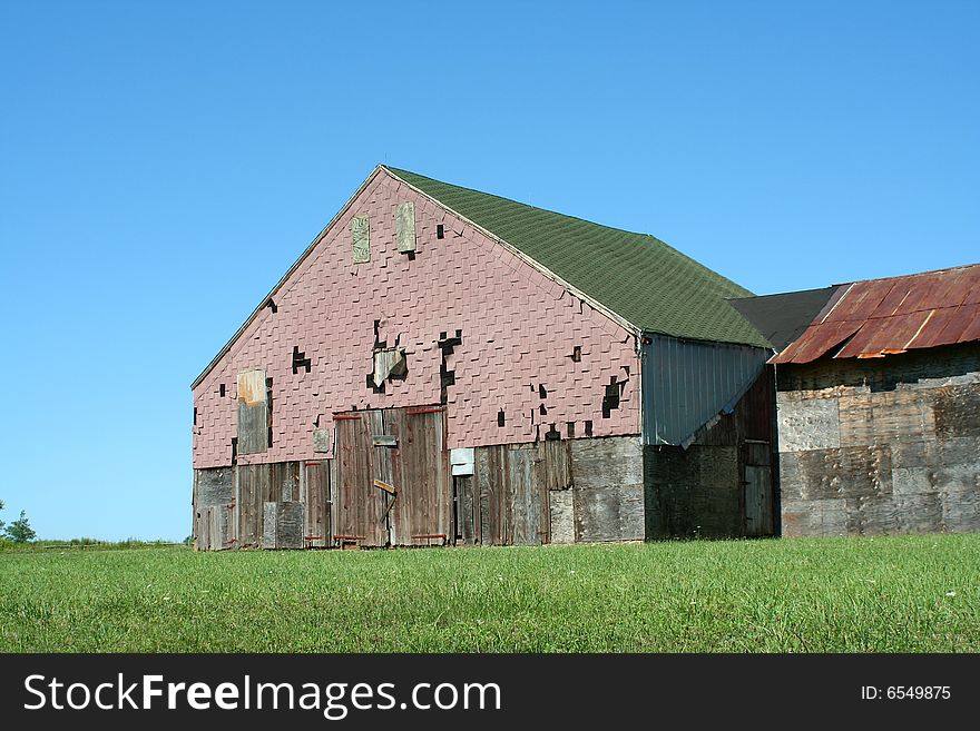 A Old barn with grass and blue sky