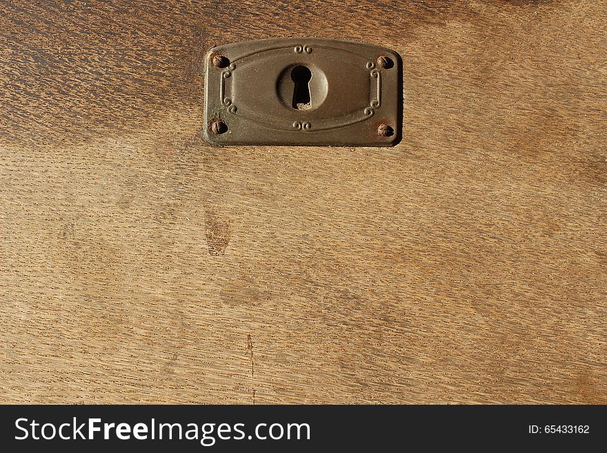 A grainy old wooden surface with a lock in the top. A grainy old wooden surface with a lock in the top.