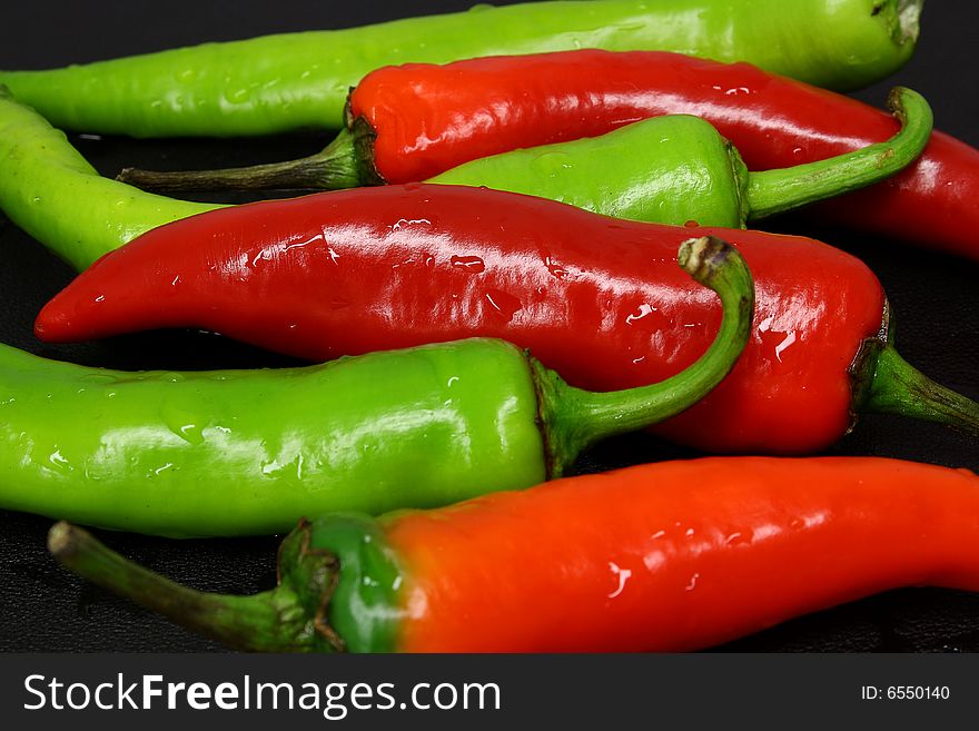 Red and green peppers on a dark background