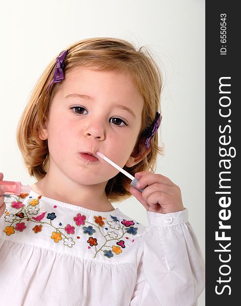 Pretty blond toddler playing makeup