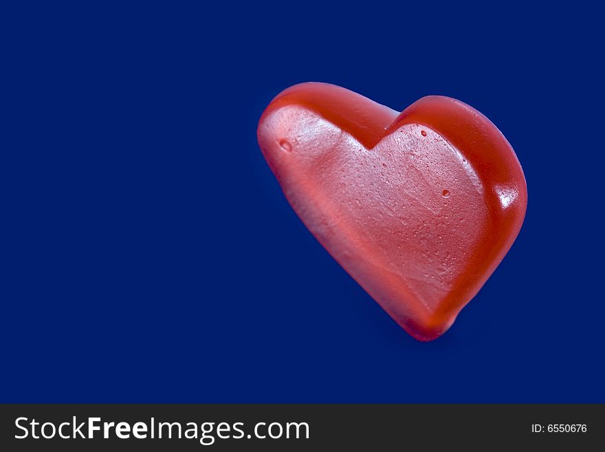 Red candy heart isolated on blue background