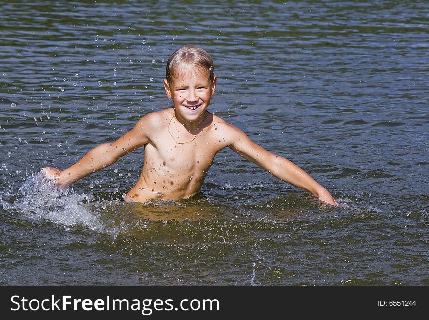 The boy was swimming in the river and splash water. The boy was swimming in the river and splash water