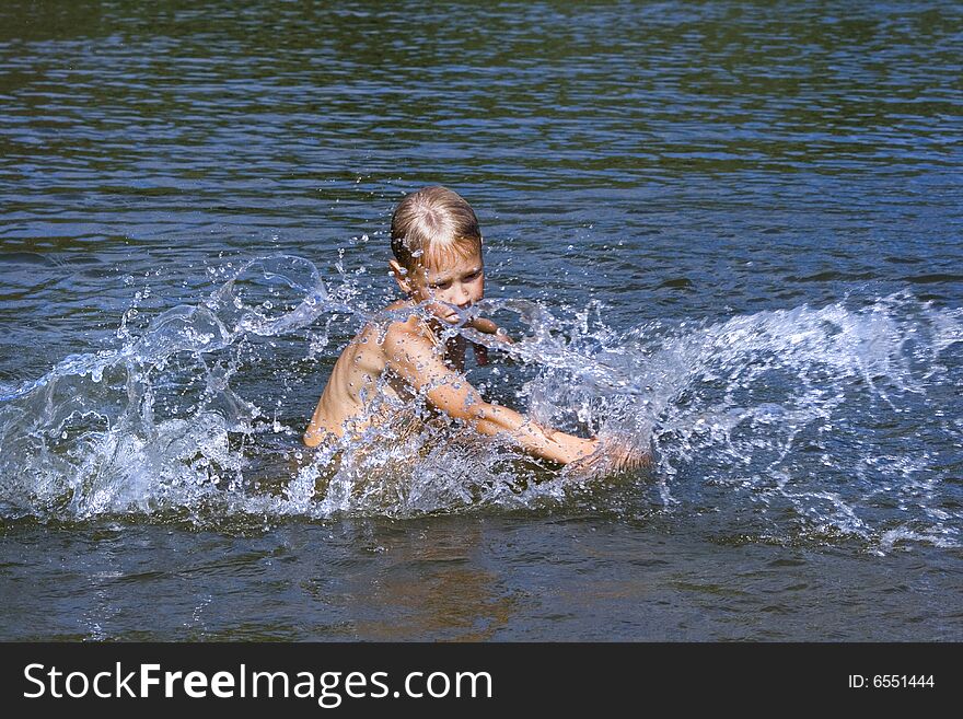 The boy was swimming in the river and splash water. The boy was swimming in the river and splash water