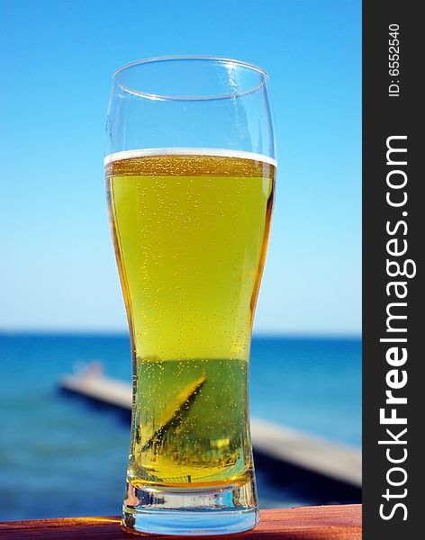 Glass of beer on a blue sea background