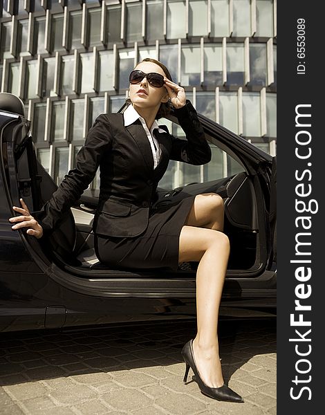 Attractive brunette businesswoman in a cabrio car
