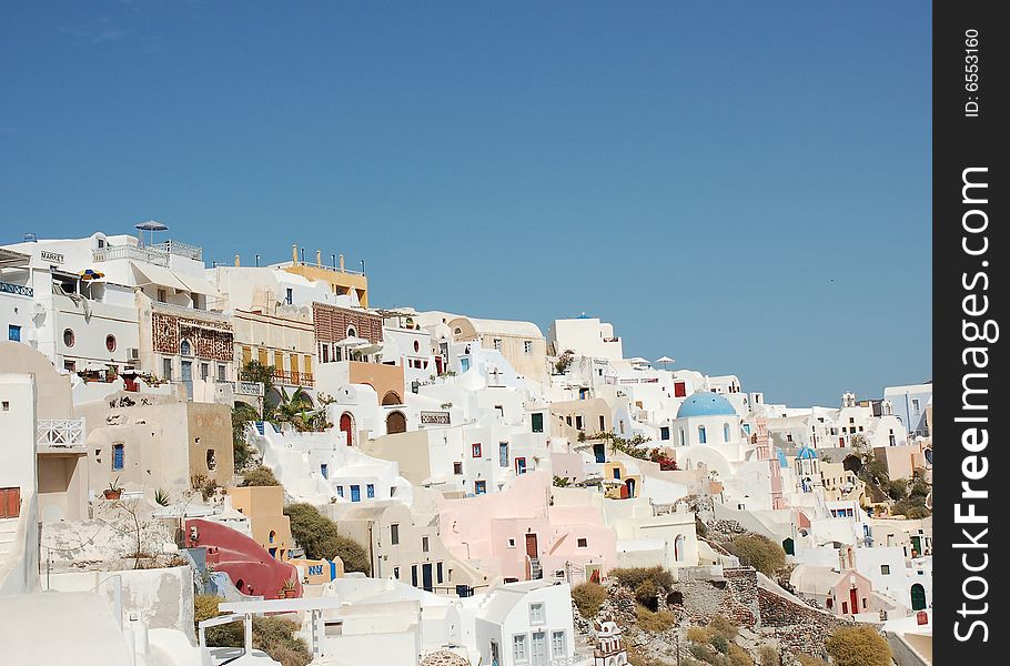 Brightly painted houses, villas and hotels perched on the edge of the cliff on the Greek island of Santorini. Brightly painted houses, villas and hotels perched on the edge of the cliff on the Greek island of Santorini.