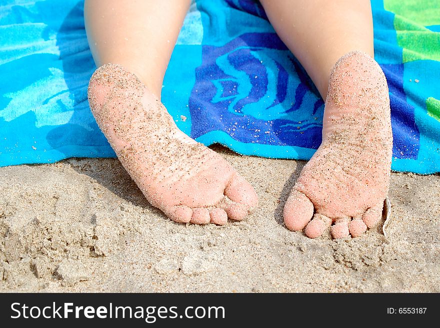 Sandy toes take a rest at the beach. Sandy toes take a rest at the beach