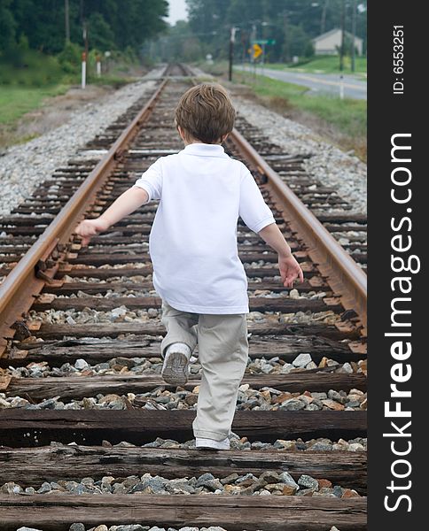 Child walking on the railroad tracks. Child walking on the railroad tracks