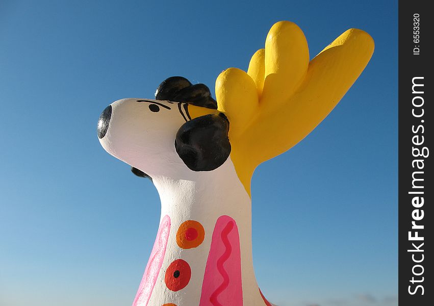 The golden antlers stag from fire-clay on the blue sky background. Hand made Dymka-toy. Russian national traditional toy from Vyatka town. The golden antlers stag from fire-clay on the blue sky background. Hand made Dymka-toy. Russian national traditional toy from Vyatka town.