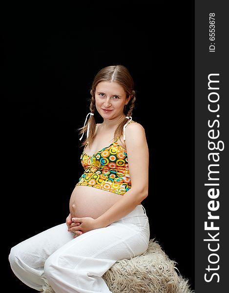 Young expectant mother on black