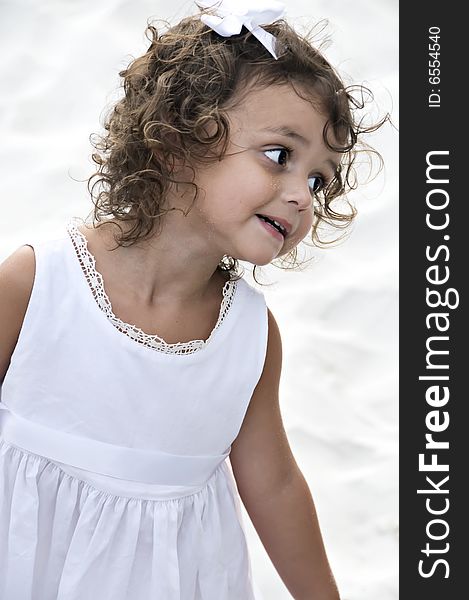 Cute little girl with curly hair making a silly face.