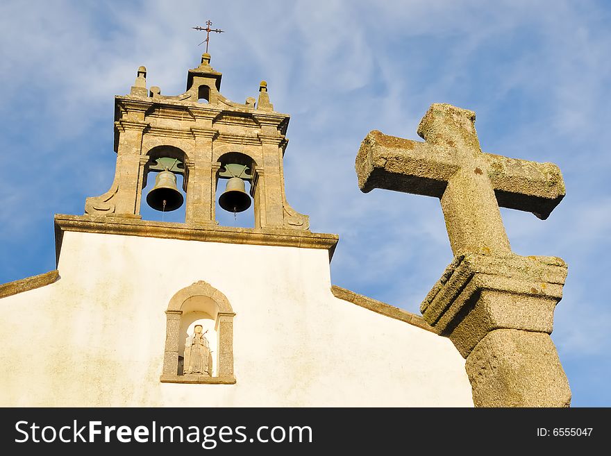 Church tower with bells and stone cross. Church tower with bells and stone cross