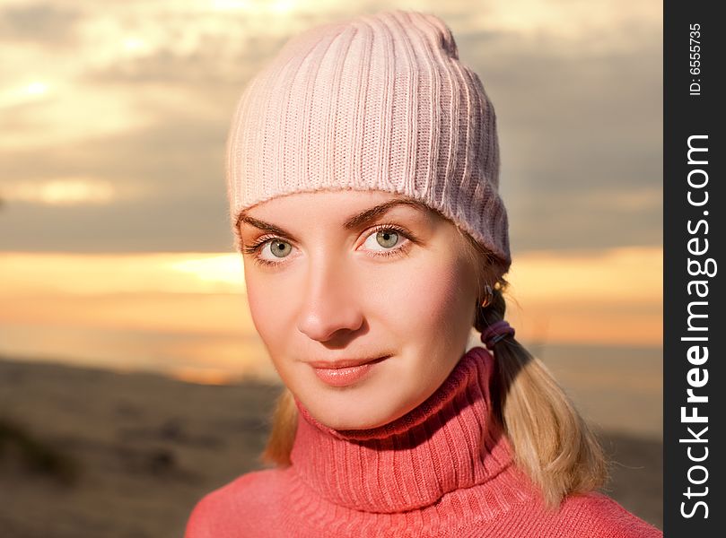 Young woman on a beach at sunset. Close-up portrait