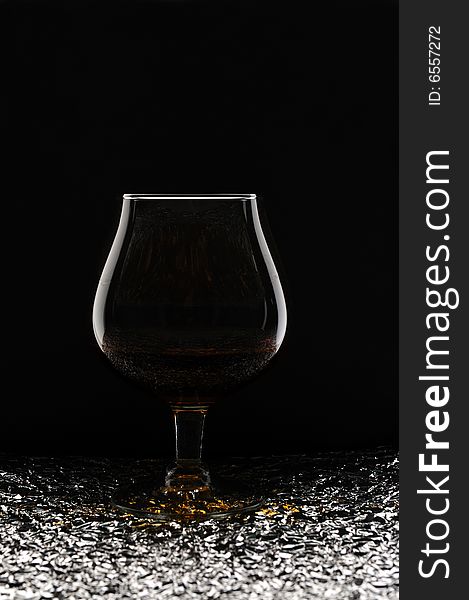 Glass of brandy against black background