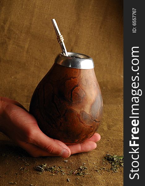 Hand holding traditional calabash for drinking mate