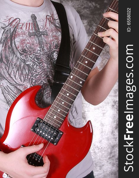 Teen boy  playing the red electric gutiar. Teen boy  playing the red electric gutiar