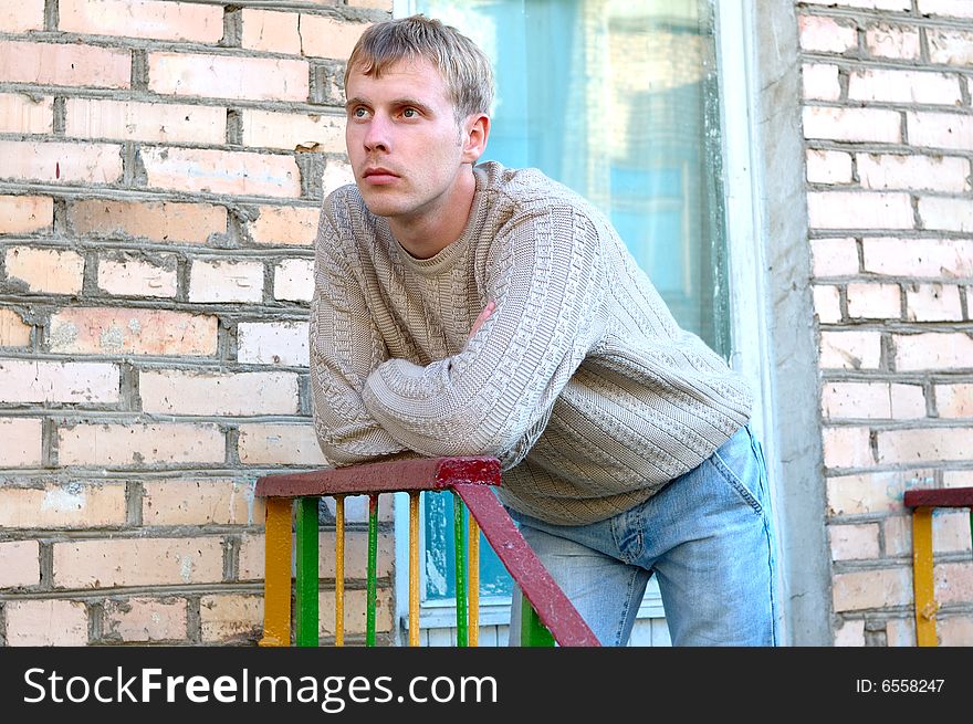 Young Stylish Man Stay On Stairs Near Brick Wall.