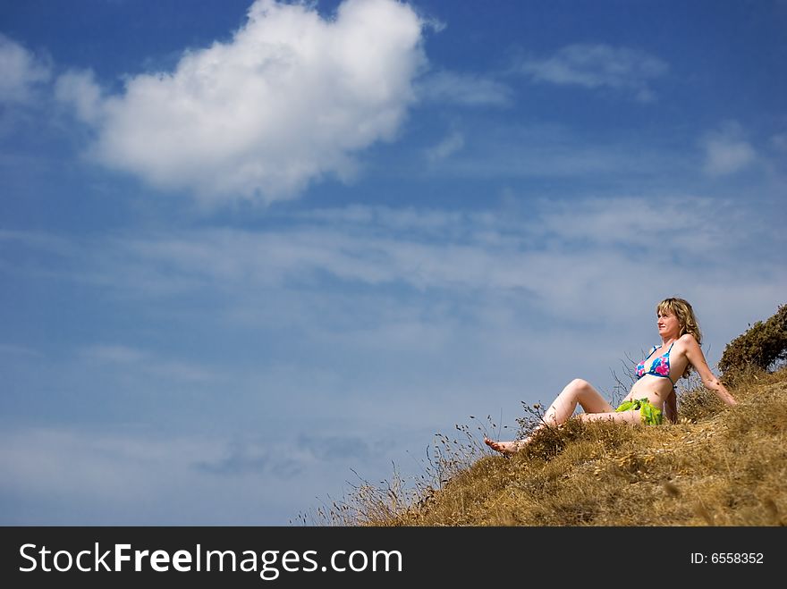 Girl sits on a grass and looks in the sky. Girl sits on a grass and looks in the sky