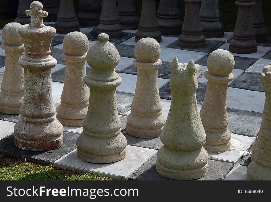Set of chess pieces ready to be played, layed out on the lawn in the garden. Set of chess pieces ready to be played, layed out on the lawn in the garden