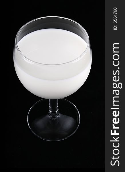 Glass of milk isolated on black background