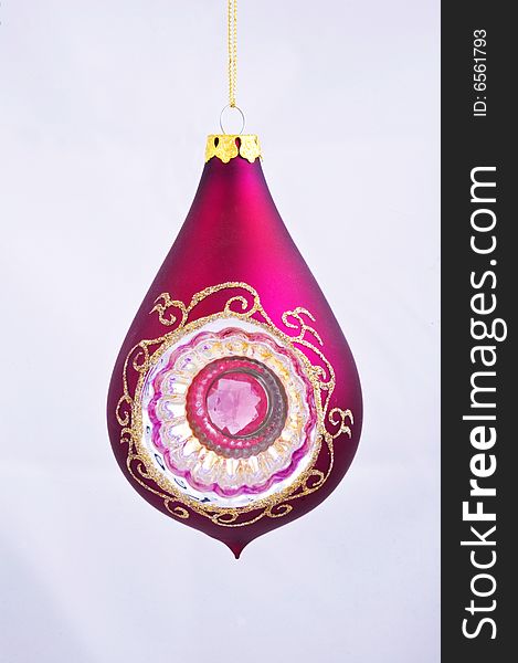 A pear shaped pink Christmas tree ornament against a white background. A pear shaped pink Christmas tree ornament against a white background.