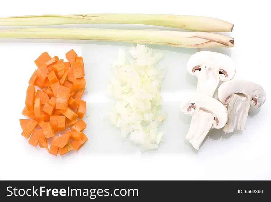 Sliced carrots, onions and champignons on a glass chopping board. Sliced carrots, onions and champignons on a glass chopping board