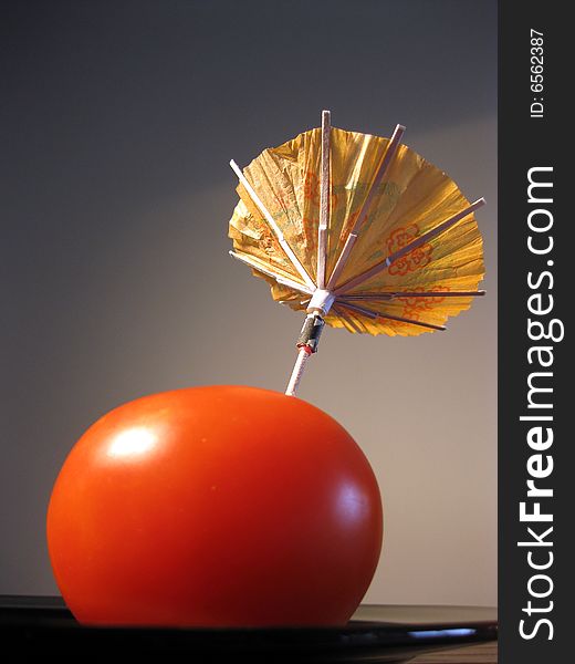 Red tomato with party umbrella metaphor of vegetable drink. Red tomato with party umbrella metaphor of vegetable drink.