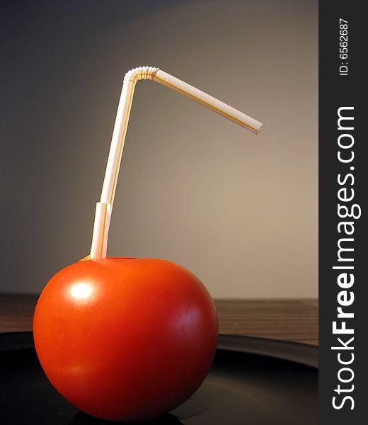 Red tomato with party plastic straw metaphor of drink. Red tomato with party plastic straw metaphor of drink.