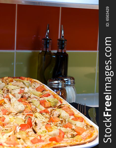 An image of Greek style pizza with artichokes and chicken