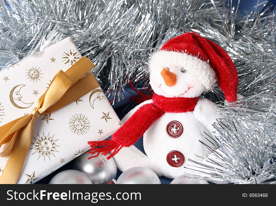 Wrapped christmas gifts with tinsel and snowman decoration