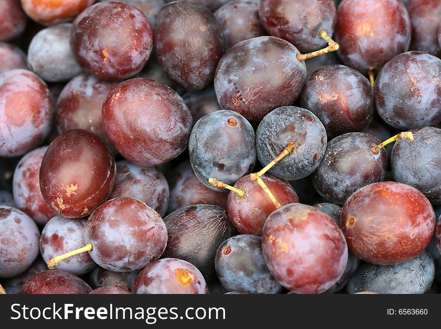 Many of violet plums in the basket