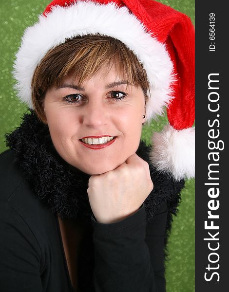 Adult female wearing a christmas hat, against a green background. Adult female wearing a christmas hat, against a green background