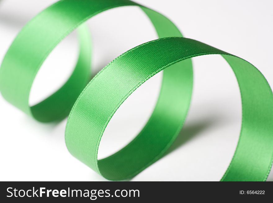 Green ribbon curling on white background. Green ribbon curling on white background