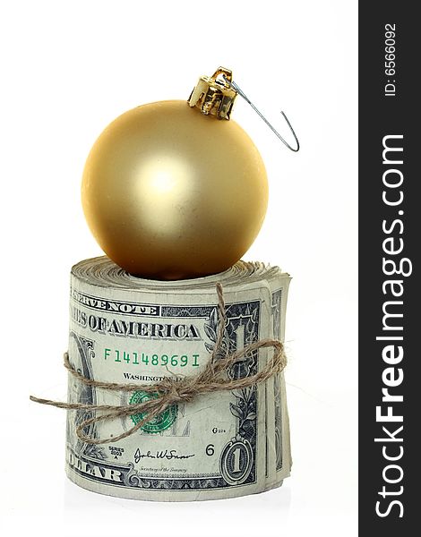 Money Roll with Christmas Ball Ornament Sitting on Top, Isolated against White. Money Roll with Christmas Ball Ornament Sitting on Top, Isolated against White