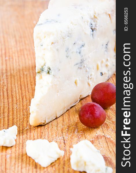 Blue stilton with grapes on a wooden board
