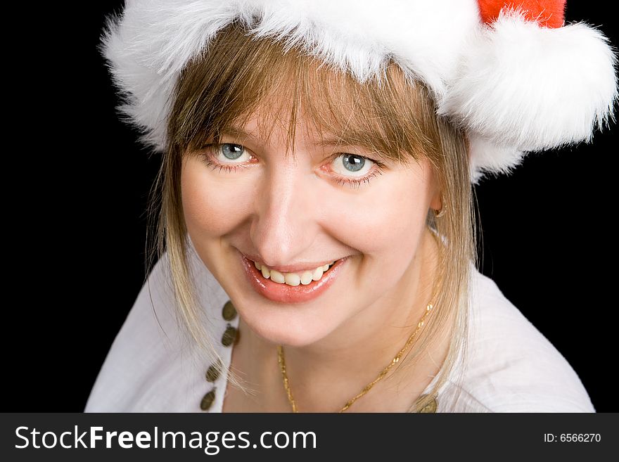 A pretty girl smiling with a christmas hat and a black background