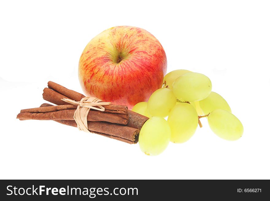Apple grapes and cinnamon sticks on white