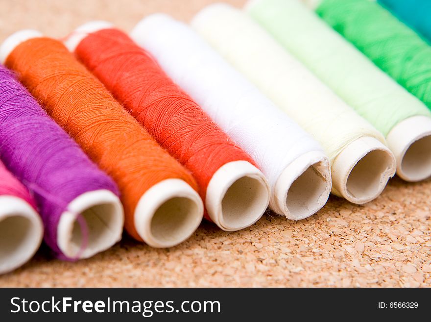 Rolls of colorful cotton on a cork background. Rolls of colorful cotton on a cork background