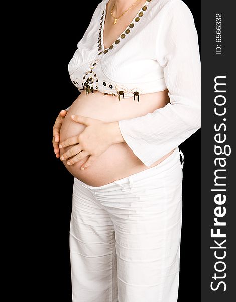 A pregnant lady feeling her tummy with a black background. A pregnant lady feeling her tummy with a black background