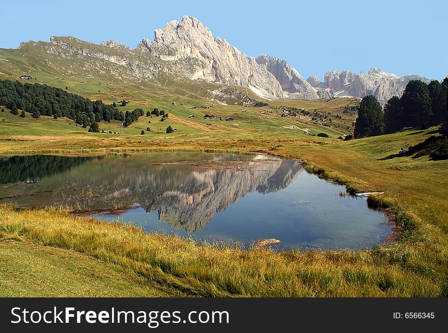 Mountains and trees reflected in a lake situated in the Dolimites, Italy. Mountains and trees reflected in a lake situated in the Dolimites, Italy