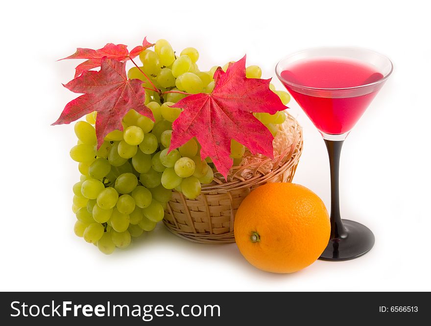 Autumn green sweet grapes and red maple leaves on white background