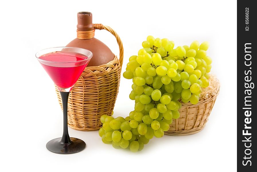 Cluster of tasty sweet green grapes in yellow basket and wine on white background