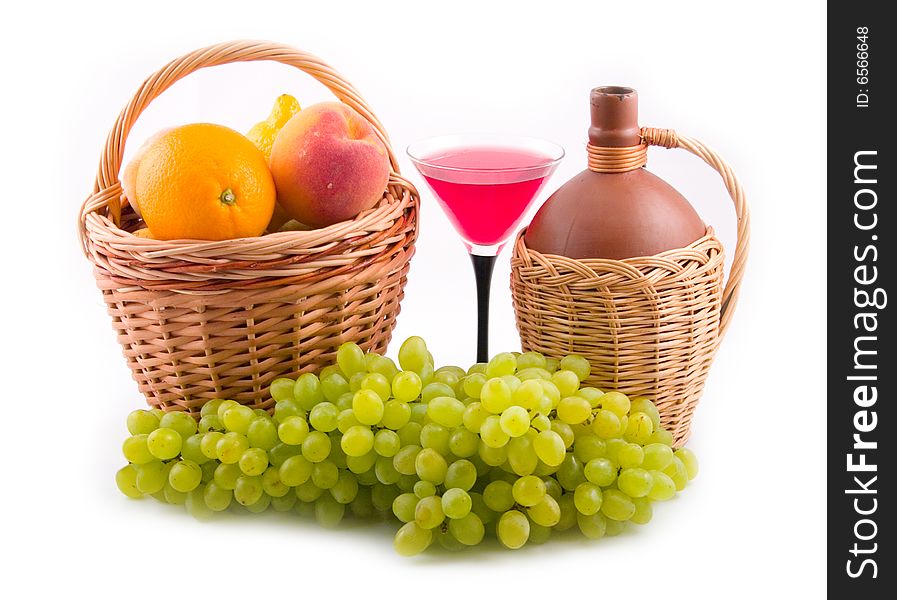 Green tasty grapes and bottles in yellow baskets on white background