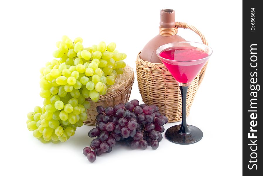 Red and green sweet grapes with bottle in basket on white background