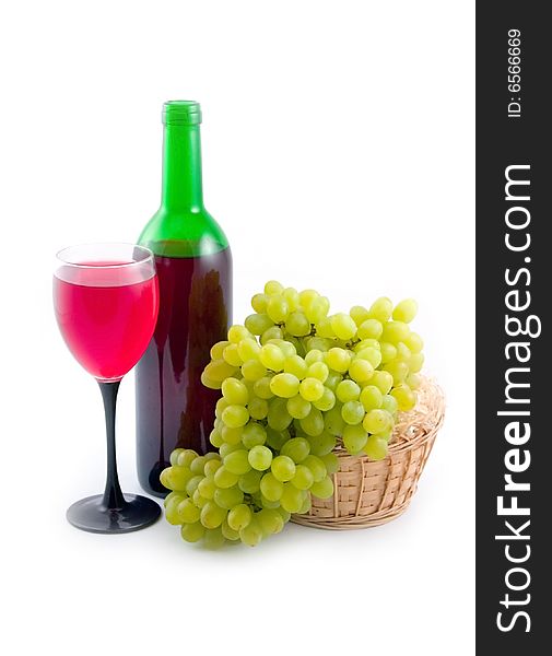 Green bottle with red wine and ripe tasty grapes on white background